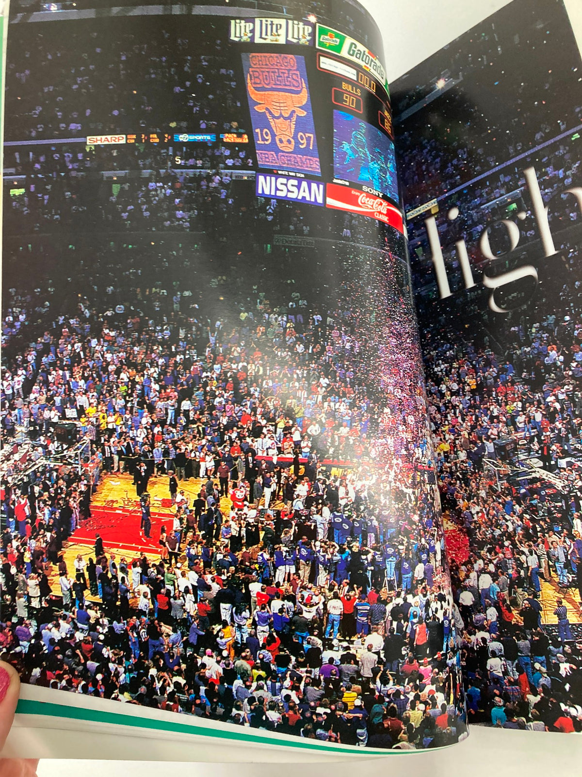 A vibrant crowd celebrating in the stadium following the Chicago Bulls' sweep victory, highlighting the championship moment in the NBA Chicago Bulls Official 1997 - 1998 Yearbook featuring Michael Jordan.