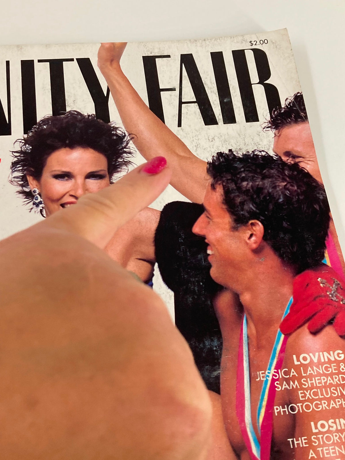 Detailed view of the VTG Vanity Fair Magazine October 1984 cover featuring Raquel Welch and male models, capturing the essence of 80s fashion.