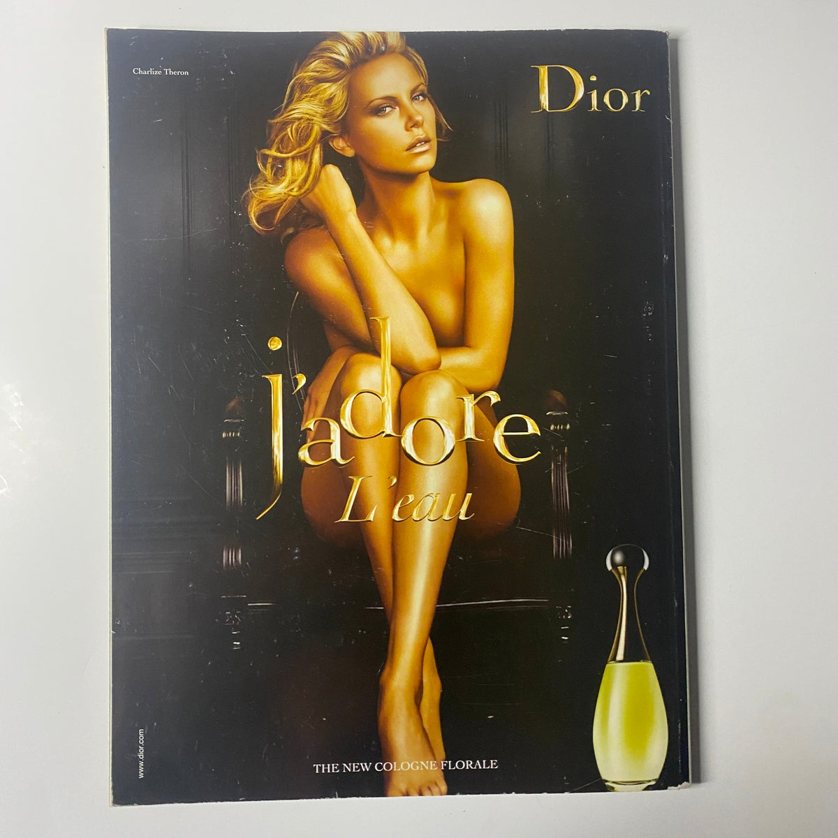 Harper's Bazaar British Magazine April 2009 includes an elegant promotional cover for Dior's j'adore L'eau perfume with a stunning model posing in an alluring gold-themed setting.
