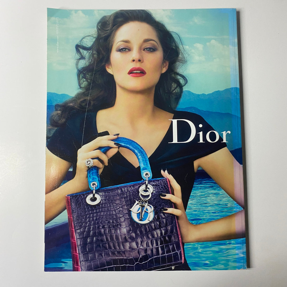 Harper's Bazaar UK Magazine February 2012 Uma Thurman Cover No Label VG displays an advertisement for Dior featuring a fashionably styled model holding a luxurious handbag against a scenic background.