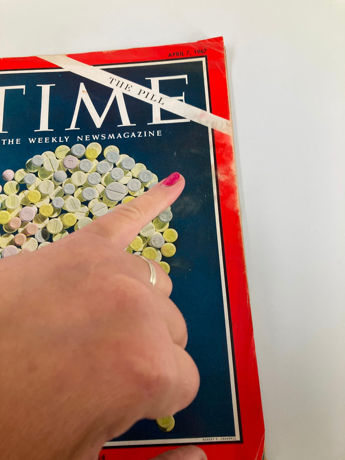 Close-up of the cover of VTG Time Magazine April 7, 1967 with a hand pointing to the title 'The Pill,' highlighting its significance in discussions about family and medication.