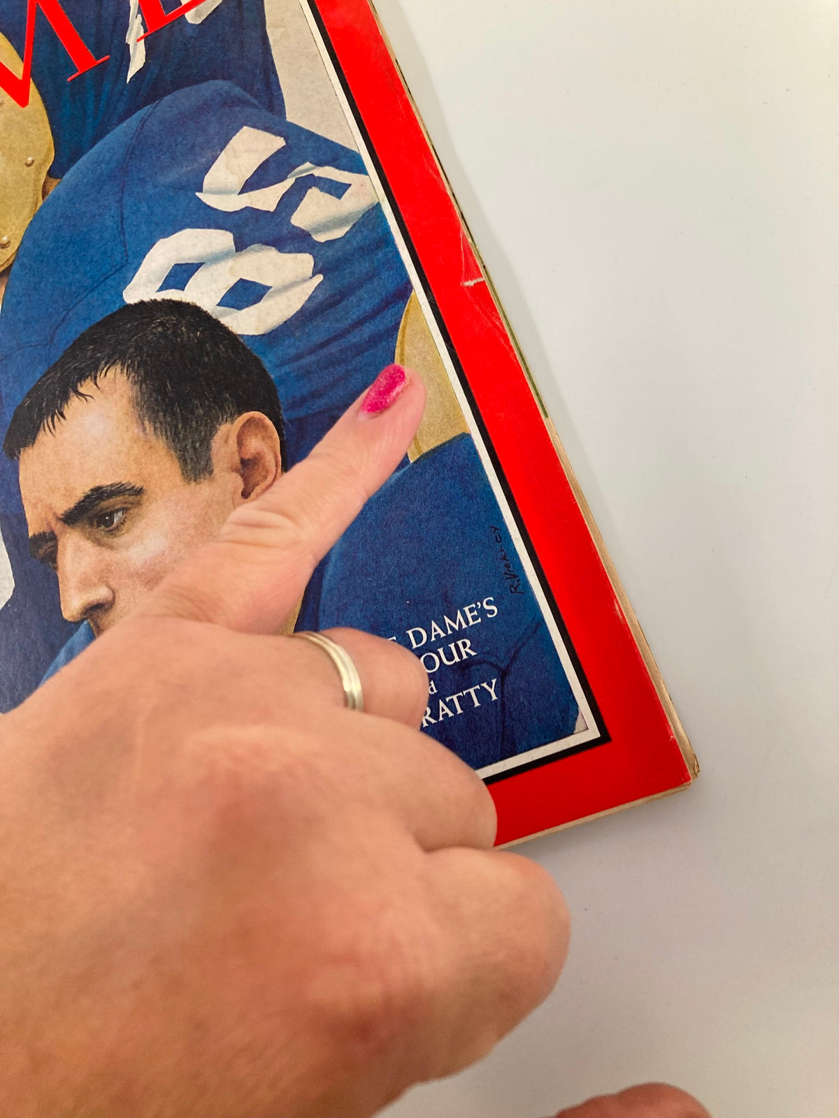 Close-up of Time Magazine cover from October 28, 1966, highlighting Notre Dame's Seymour and Hanratty with a hand pointing to the title section, reflecting sports memorabilia.