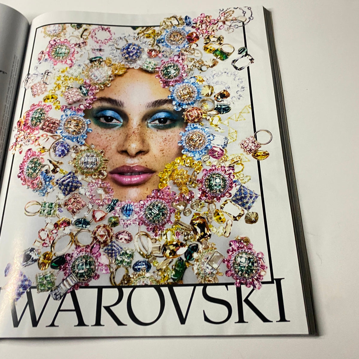 Fashion editorial page from Harper's Bazaar Magazine September 2021 showcasing a model adorned with Swarovski jewelry and vibrant makeup.