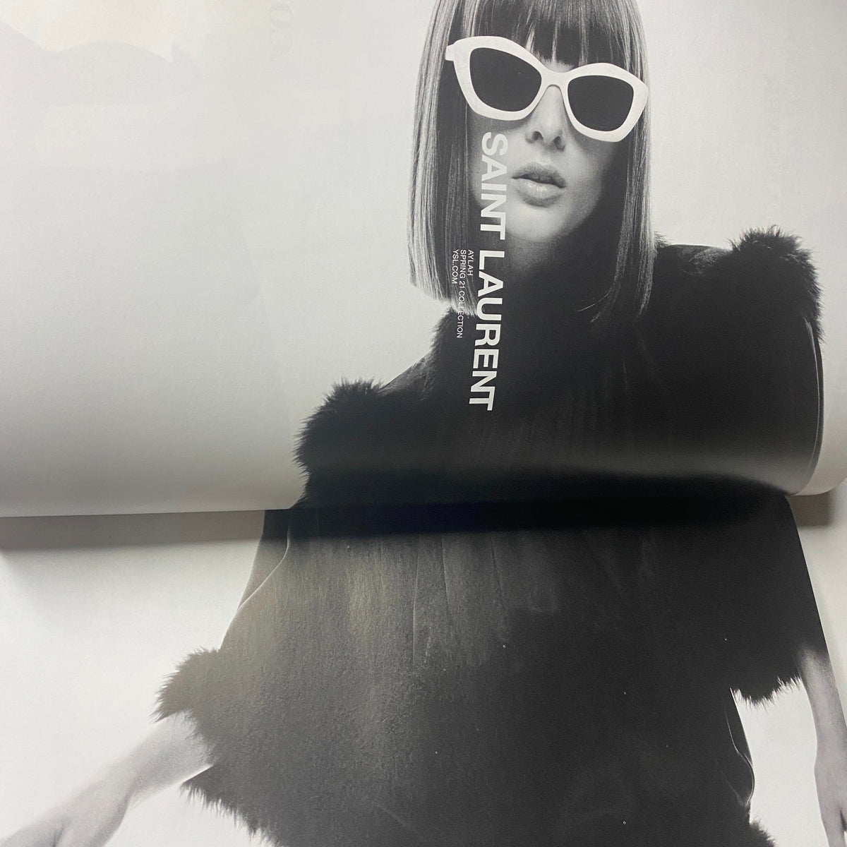 Fashion editorial from W Magazine 2021 Volume 1 highlighting a model in a stylish black outfit with white sunglasses, showcasing Saint Laurent.