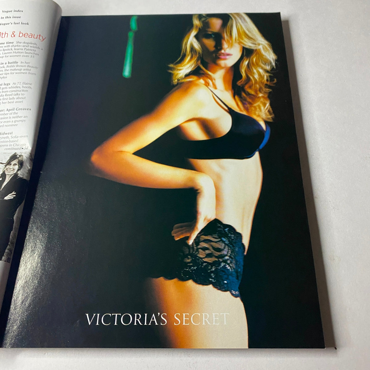 Victoria's Secret advertisement showcasing a model in a black bra and lace panties, exuding confidence and allure. Vogue Magazine – August 2002 – Jennifer Aniston Cover (No Label, Very Good Condition).