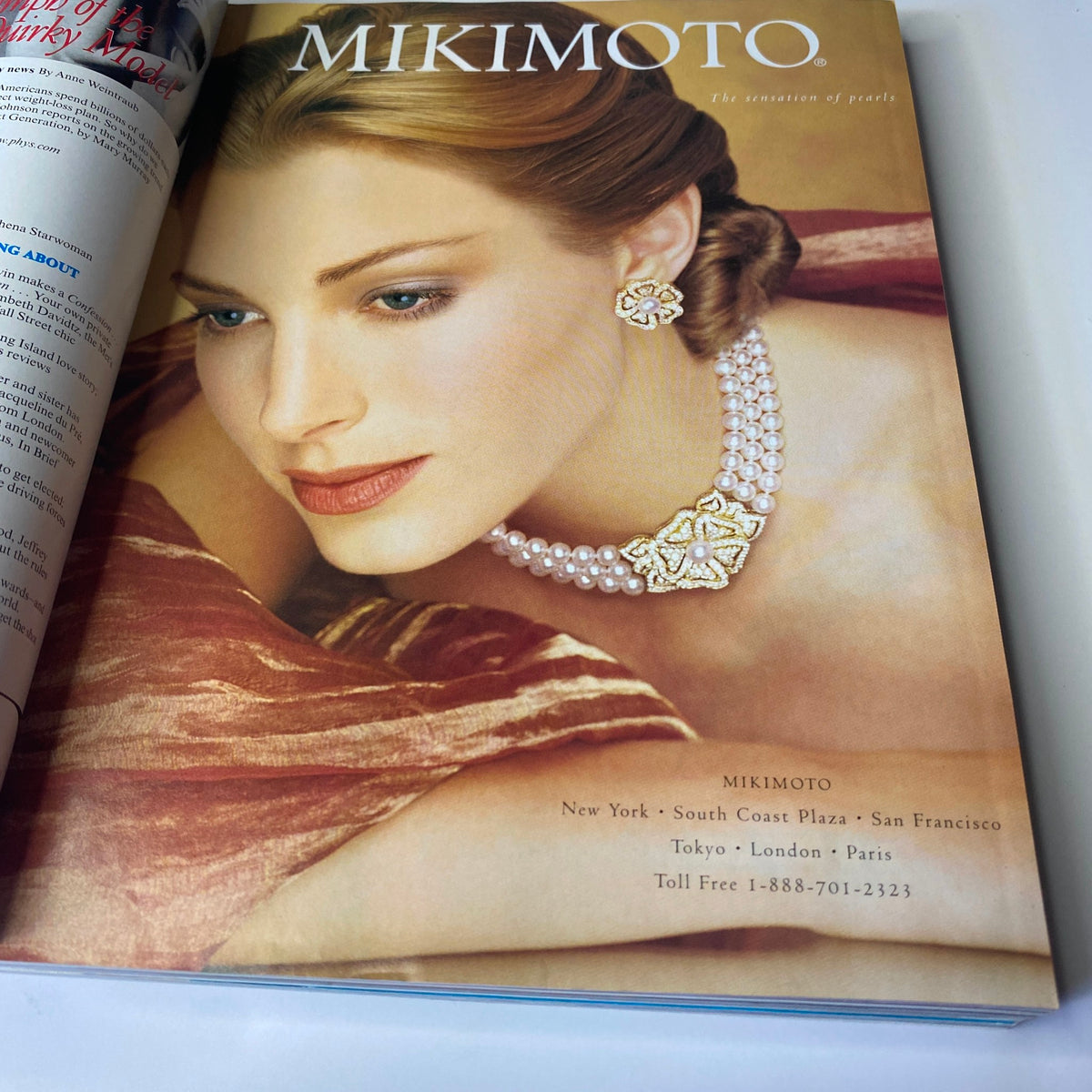 Advertisement page in Vogue Magazine March 1998 for Mikimoto, displaying luxurious pearl jewelry with a model wearing an elegant necklace.