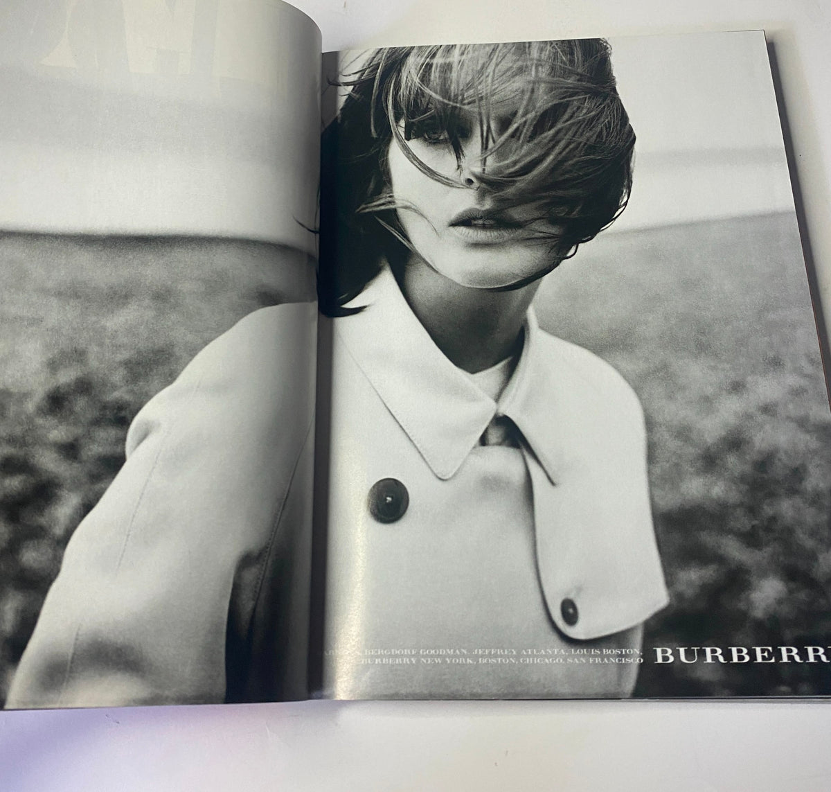 Vogue Magazine February 1999 showcasing an advertisement for Burberry featuring a black and white image of a model with wind-swept hair, emphasizing fashion and style.