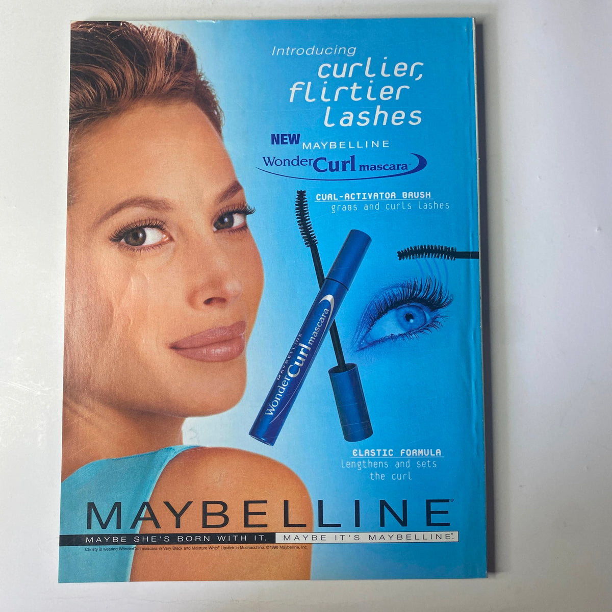 Introducing Maybelline WonderCurl mascara advertisement featuring a model with curler lashes and the slogan 'Curly, Flirty Lashes'. The flyer promotes the elastic formula of the mascara that lengthens and sets the curl.