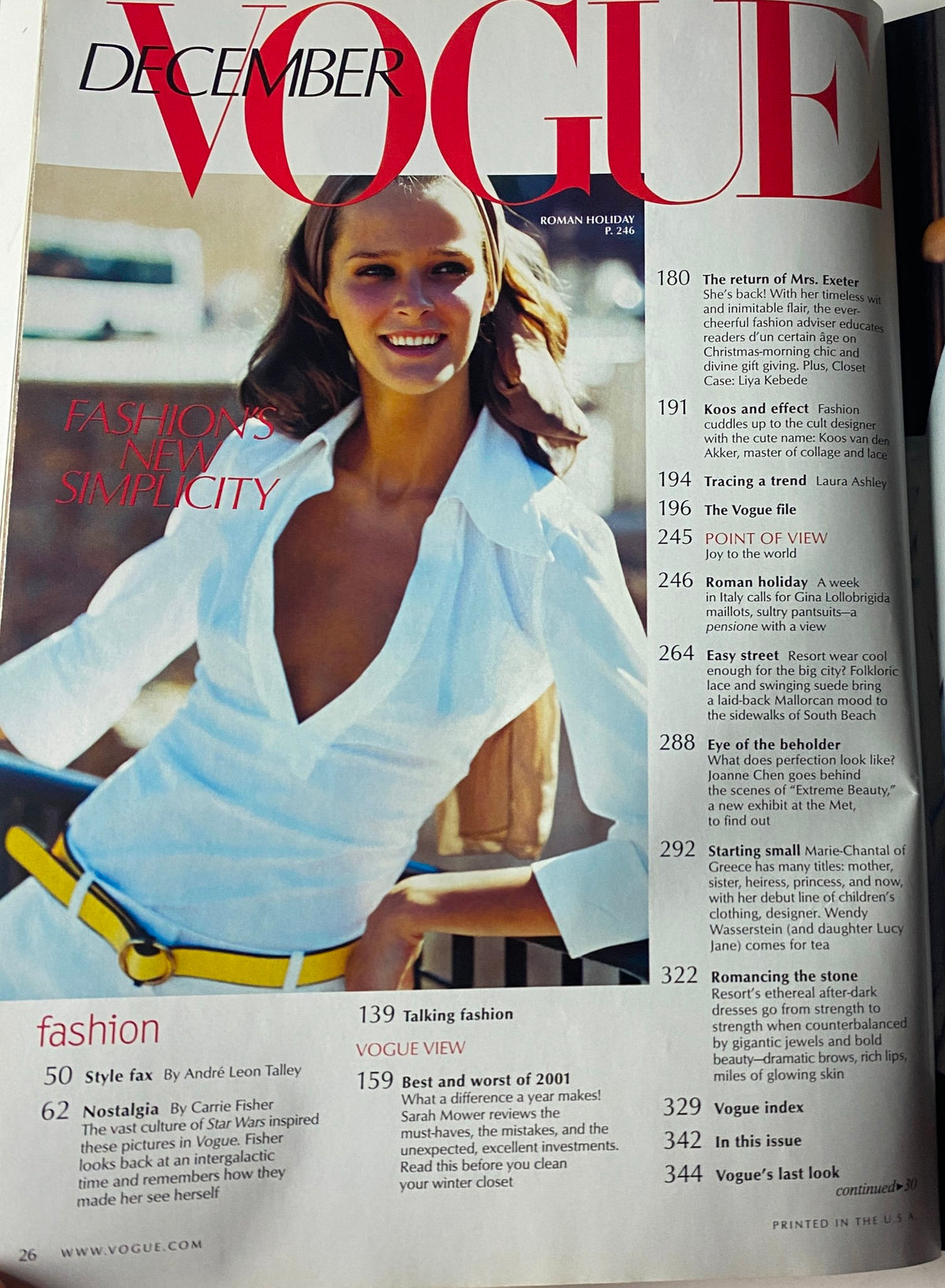 Inside page of the December 2001 Vogue Magazine showcasing the article 'Fashion's New Simplicity' with a model in a stylish white shirt and yellow belt, demonstrating seasonal fashion trends.