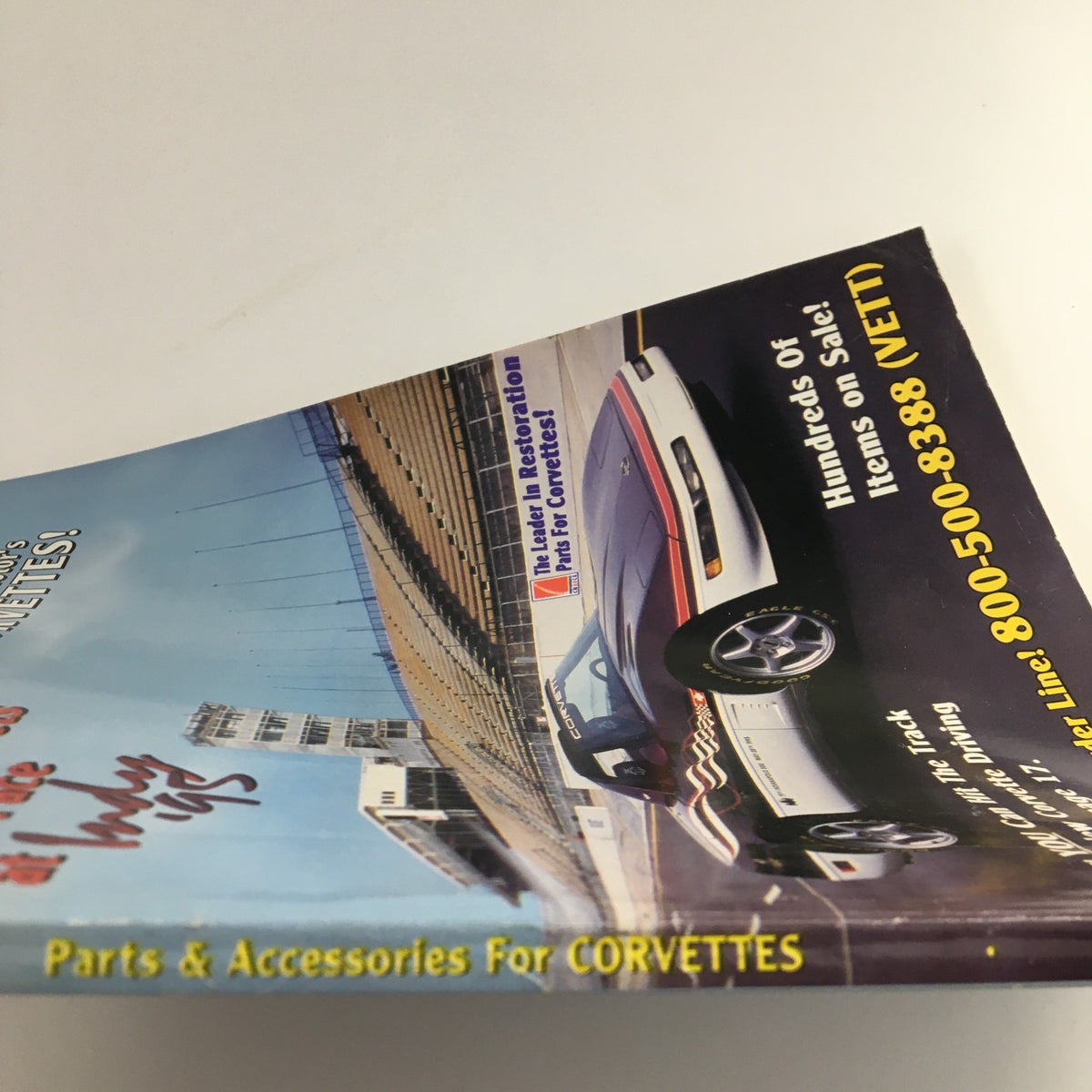 Side view of the Mid America Designers Inc. Catalog 1995 Parts & Accessories for Corvettes displaying the edge and spine of the catalog with visual elements related to Corvette parts.