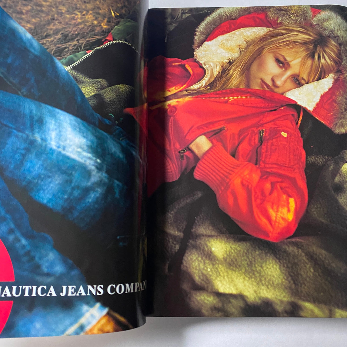 Fashion editorial featuring a model in a vibrant red jacket lounging on a cozy surface, showcased in Vogue Magazine September 2003 Nicole Kidman Cover No Label VG.