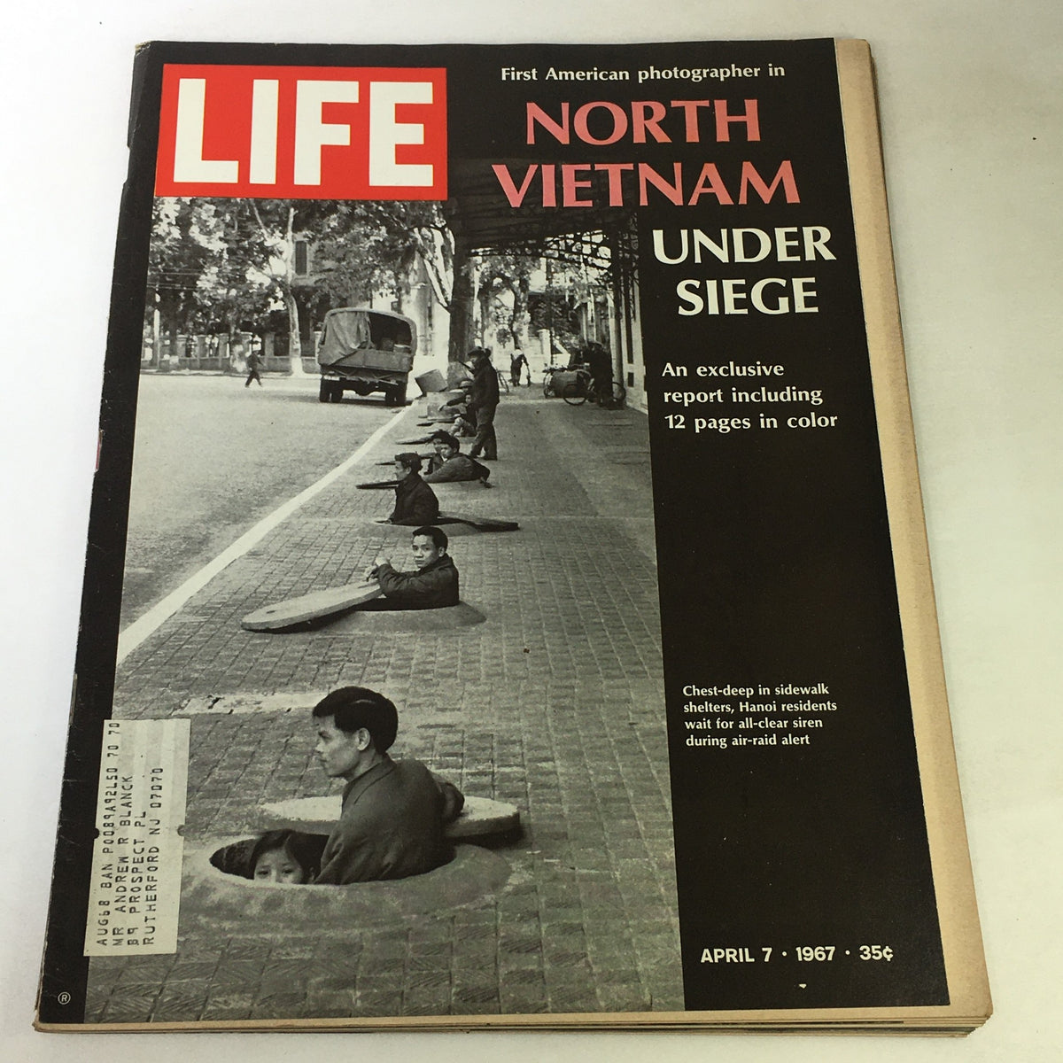 Cover of VTG Life Magazine from April 7, 1967, featuring the title 'North Vietnam Under Siege'. The image depicts Hanoi residents in sidewalk shelters during an air-raid alert, with an exclusive report including 12 pages in color.