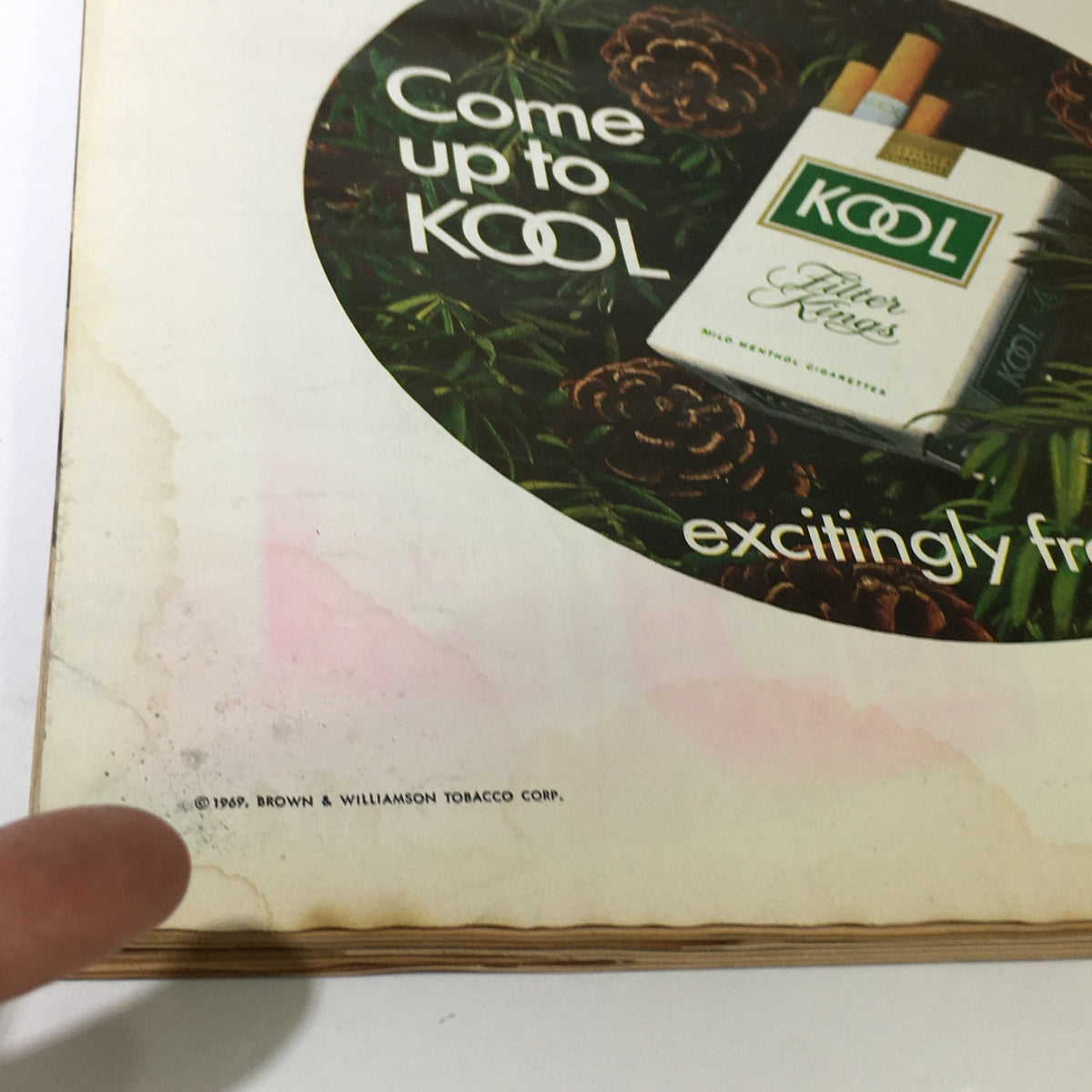 Illustration of an advertisement page from the Vintage Life Magazine December 12, 1969, featuring a Kool cigarettes ad with aging and stains.
