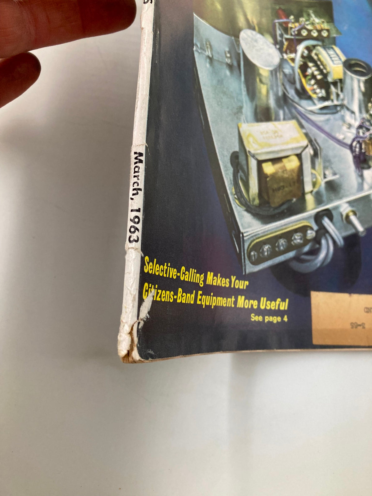 Close-up view of the spine of the VTG Radio-Electronics Magazine March 1963 showcasing the date and details of worn binding, highlighting its vintage appeal.