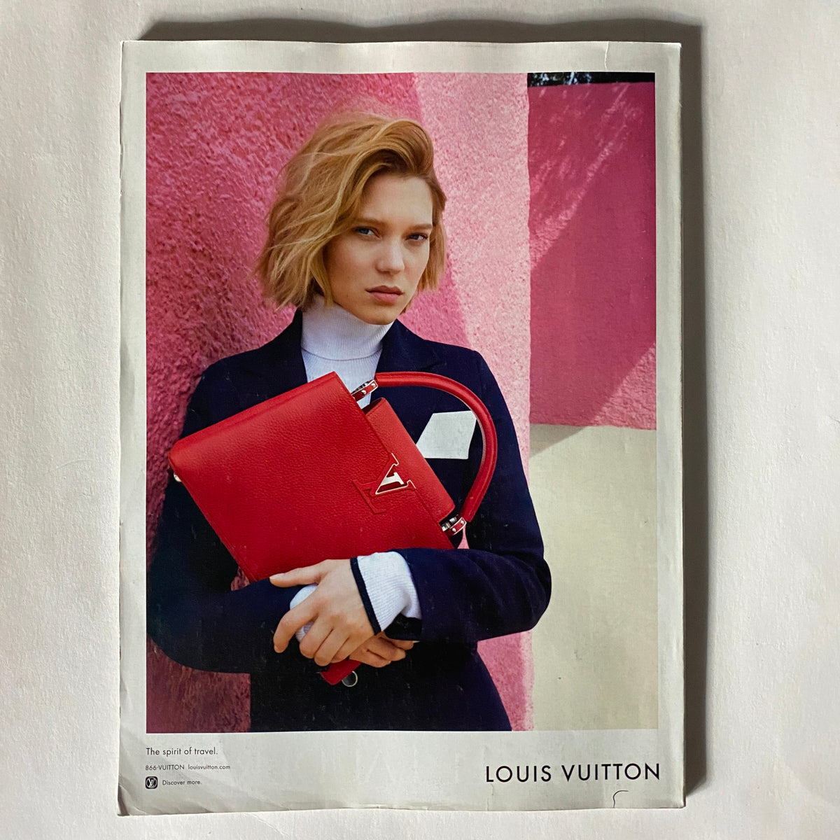 Advertisement page in Vogue US Magazine July 2016 showcasing a red Louis Vuitton handbag held by a model.