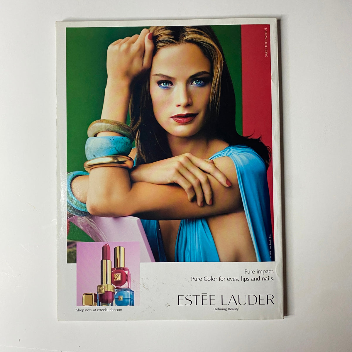 Advertisement for Estée Lauder in Vogue Magazine July 2004, showcasing makeup products and a model promoting beauty and skincare.