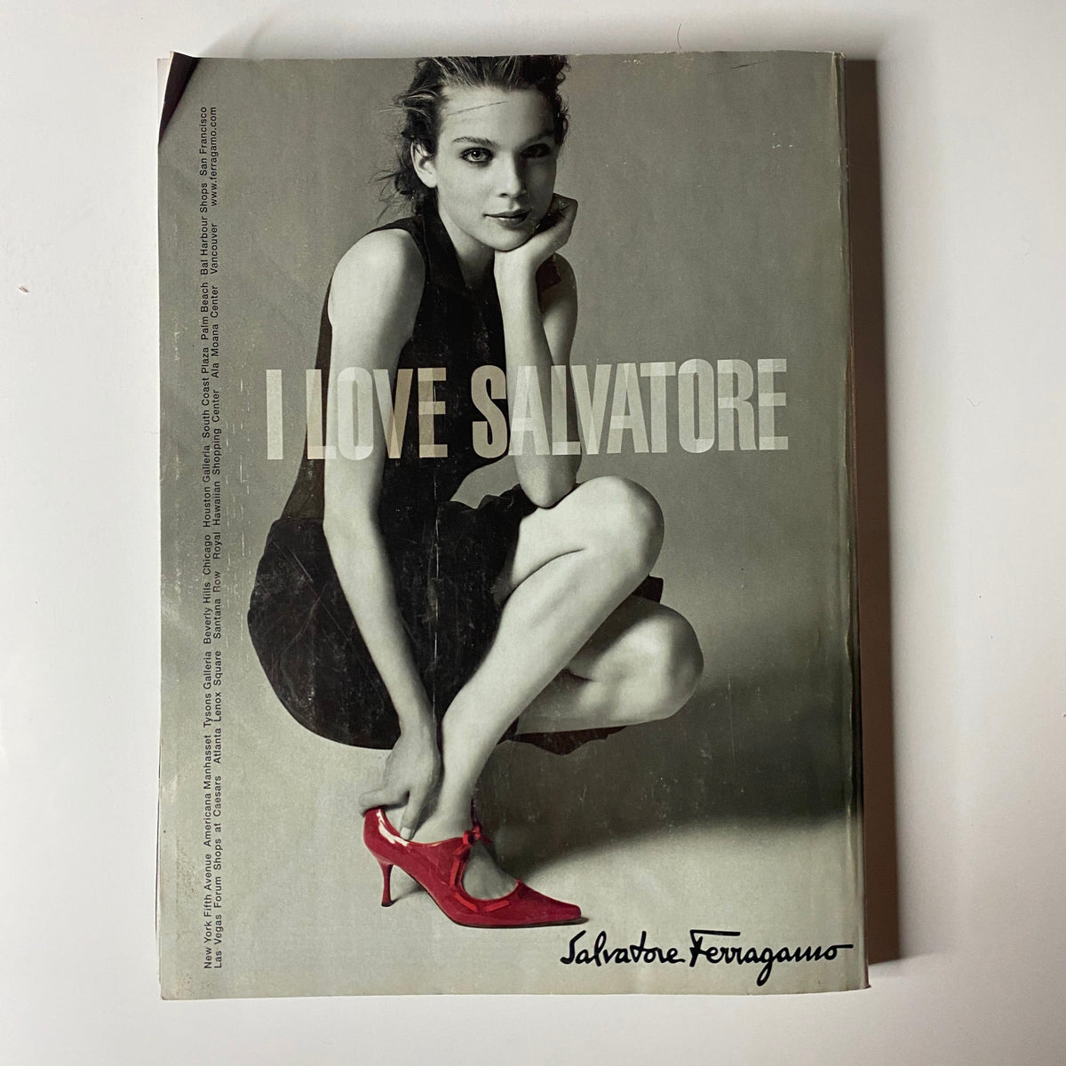Salvatore Ferragamo advertisement featuring a model in a stylish black dress and red heels. Part of the issue featuring Keira Knightley on the cover in Vogue Magazine December 2005.