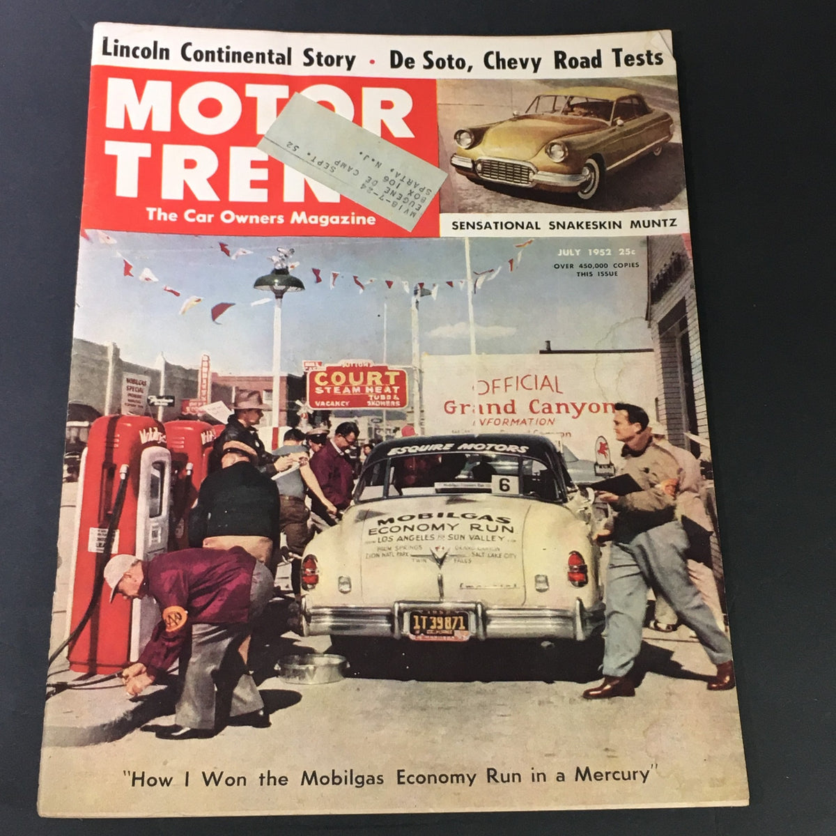 Cover of Motor Trend Magazine July 1952 featuring the Lincoln Continental story, Chevy road tests, and an image of people at a gas station with a classic car, showcasing automotive history.