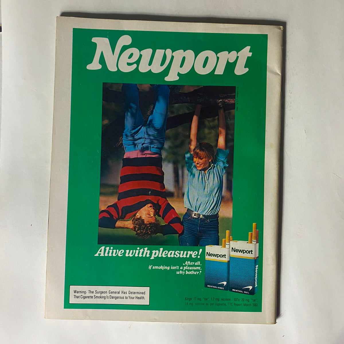 Classic Newport magazine advertisement featuring two children playing outdoors, one hanging upside down from a tree, promoting the slogan 'Alive with pleasure!' This vintage advertisement reflects the casual and playful spirit of the era.