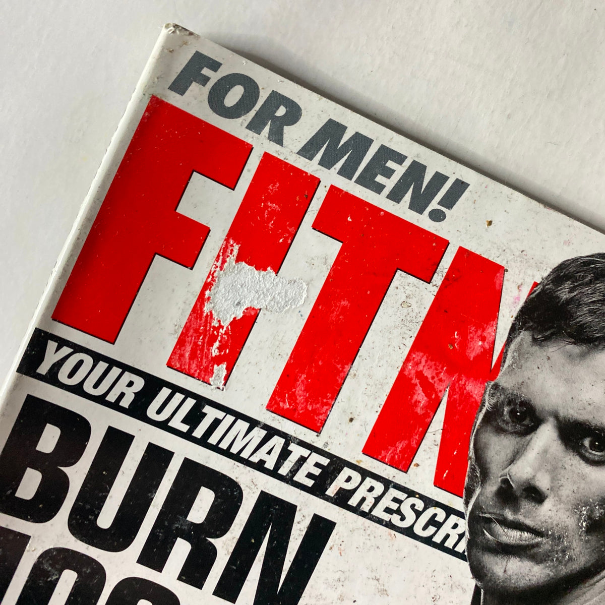 Cover of Fitness RX Magazine July 2012 featuring bold red text 'FIT' with an image of a male model showcasing fitness themes inspired by NFL Super Heroes and New York Giants workouts.