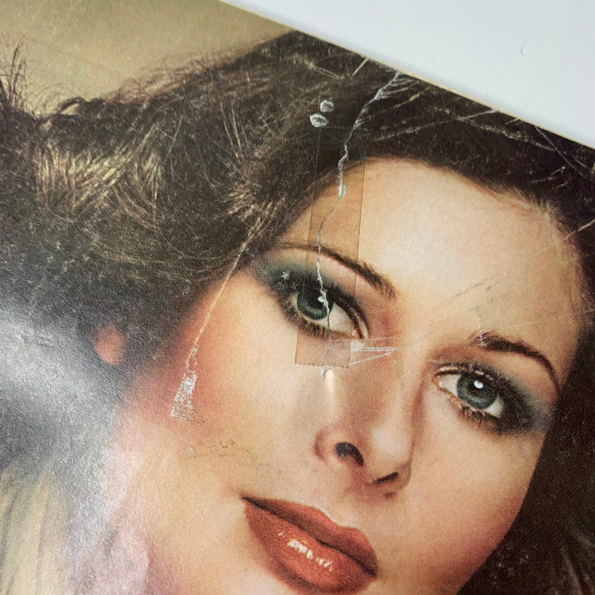 Close-up of the Vogue Magazine April 1975 cover featuring Cheryl Tiegs, emphasizing her makeup and fashion details characteristic of the 1970s beauty culture.
