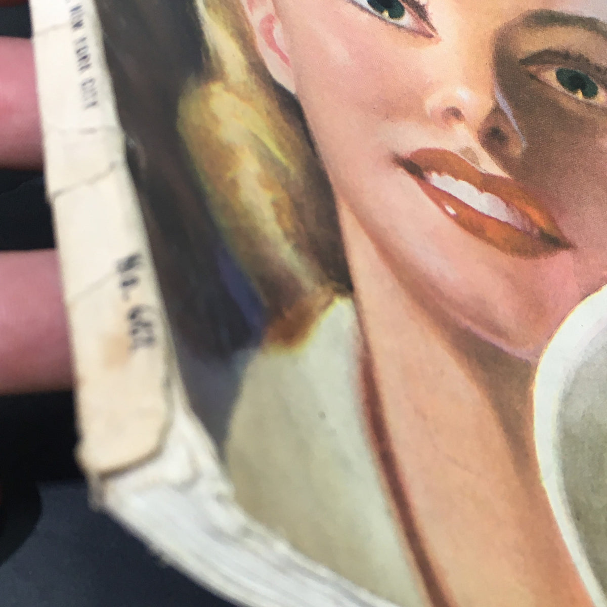 Close-up image of the VTG Cosmopolitan Magazine April 1943, focusing on the smiling woman's face, showcasing notable illustration details around her hair and dress.