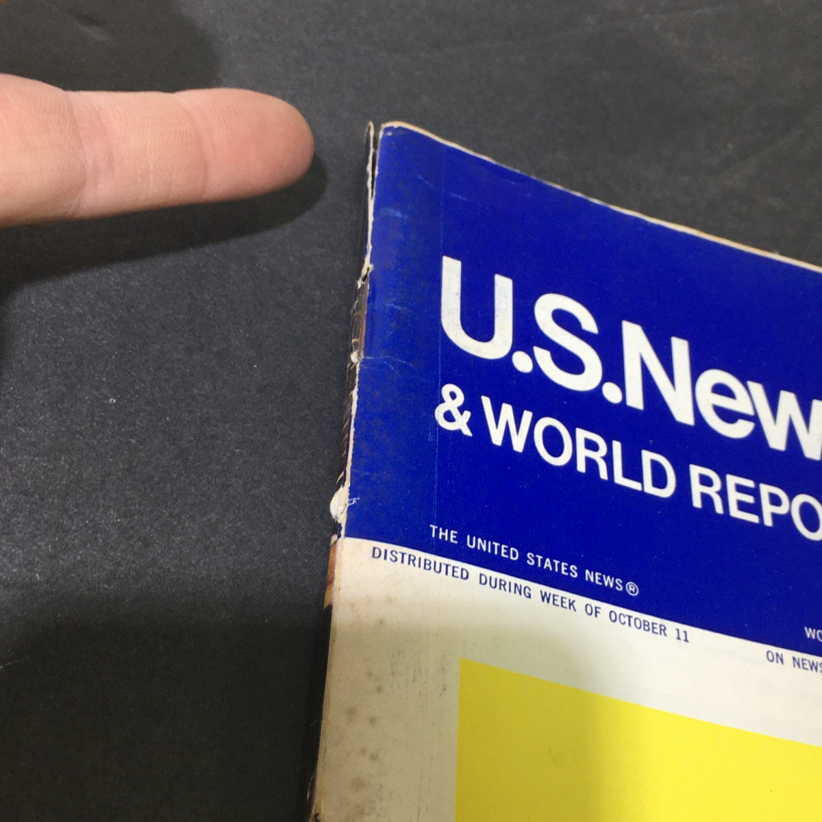 Close-up view of the spine and edge of VTG U.S. News & World Report from October 18, 1971, featuring visible wear and a finger pointing towards it.