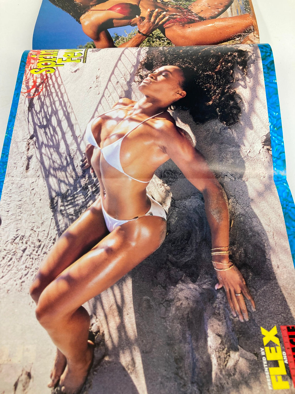 Poster spread from Joe Weider's Flex Magazine, March 1999, showcasing a bikini model on a sandy beach, emphasizing fitness and summer body inspiration.