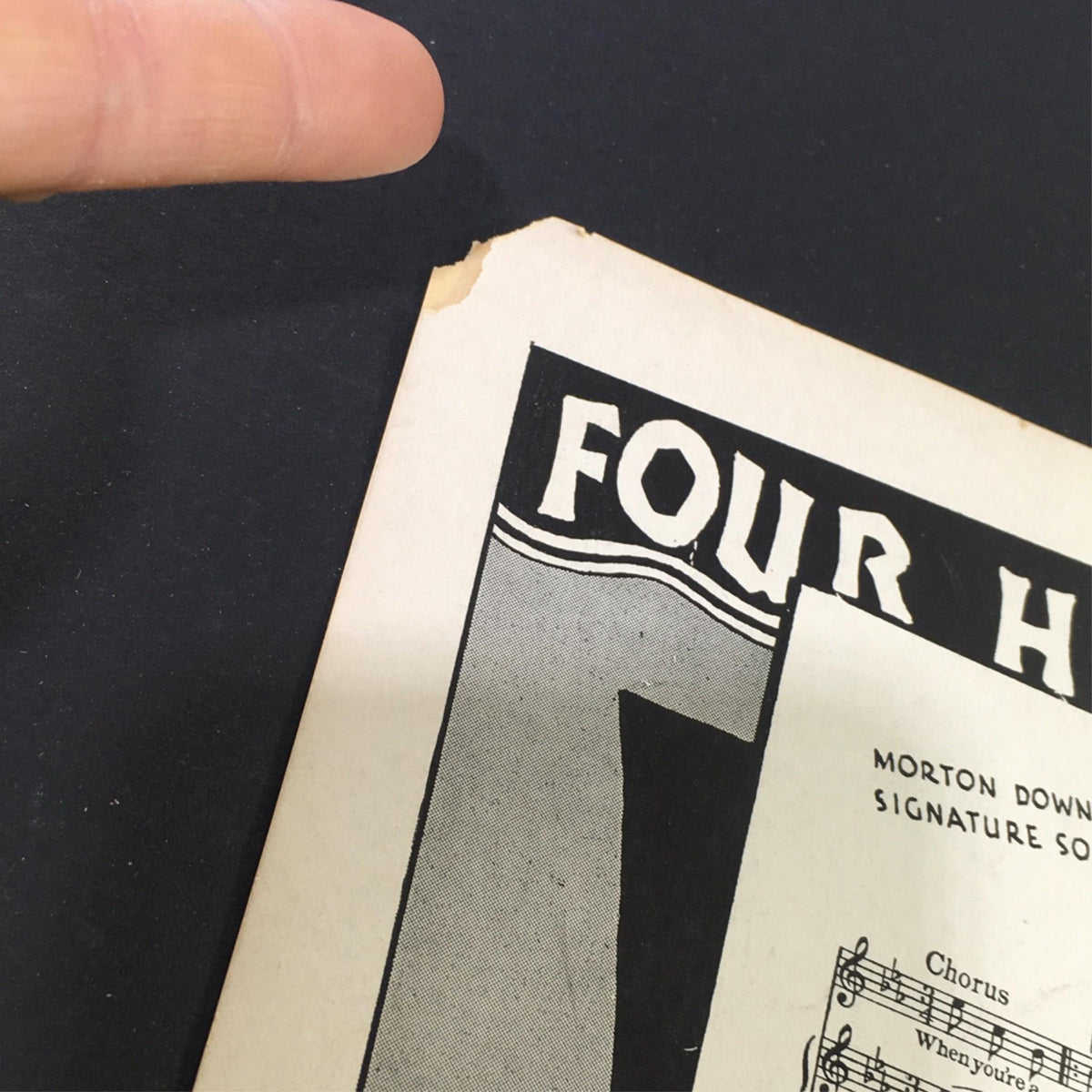 Detailed view of a worn corner of the vintage sheet music for 'I'm Thru Saying I'm Thru', indicating its historical significance and vintage charm.