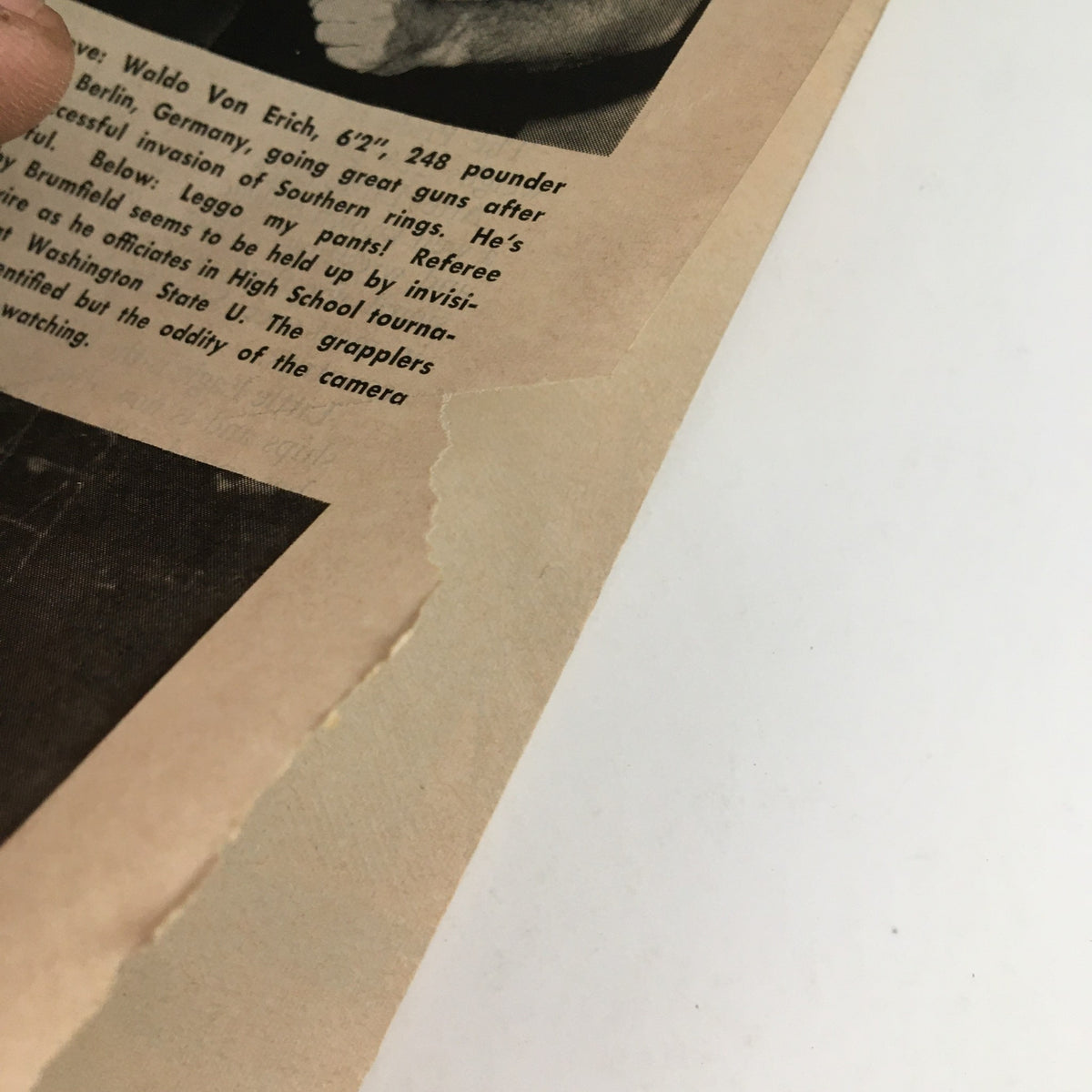 Close-up of a page corner in The Ring Boxing Magazine May 1961, highlighting minor wear with a tear, emphasizing the vintage condition of the magazine.