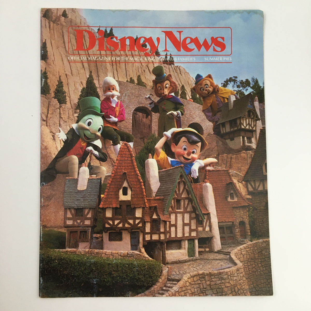 Cover of Disney News Magazine Summer 1983 featuring Pinocchio and Friends celebrating the opening of New Fantasyland with a picturesque backdrop.