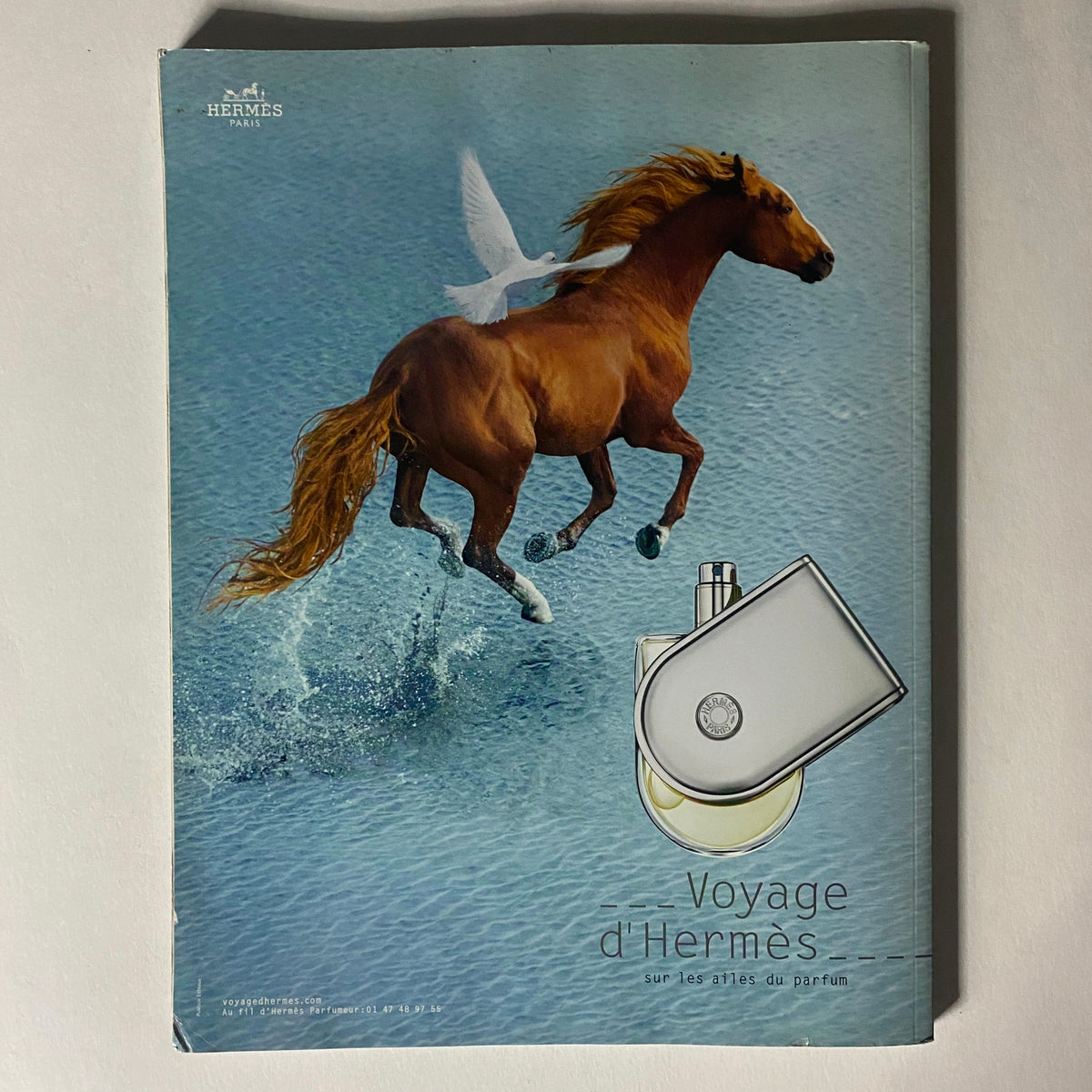 Back cover of Numéro Magazine July 2010 No. 114, featuring an advertisement for Hermès fragrance 'Voyage d'Hermès' with a horse running by the water.