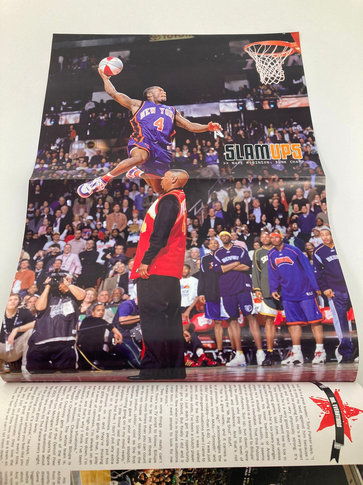 Image from Slam Magazine June 2006 featuring Chauncey Billups, depicting an exciting basketball dunk by a player in a New York jersey during an NBA event. This unique collectible magazine celebrates the legacy of Chauncey Billups and the Detroit Pistons.