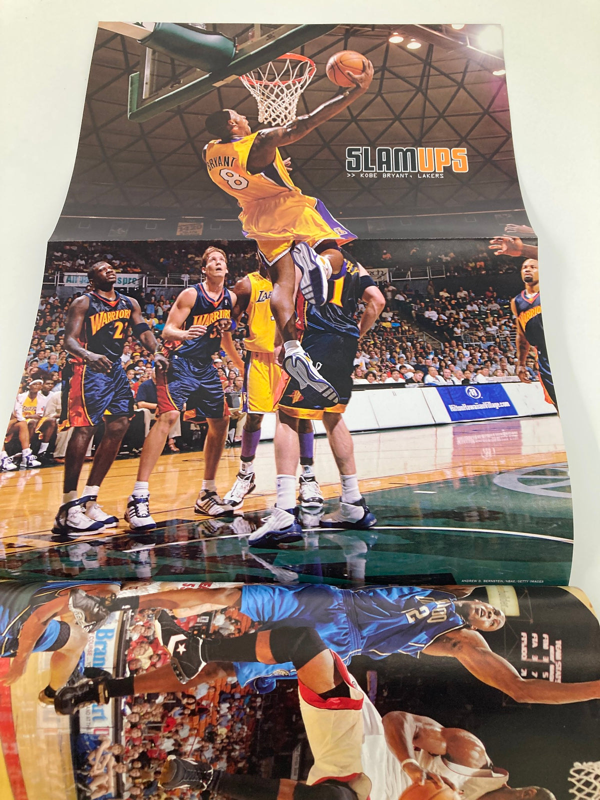 Slam Magazine February 2006 showcasing a dynamic basketball moment with Kobe Bryant making an impressive dunk against defenders.