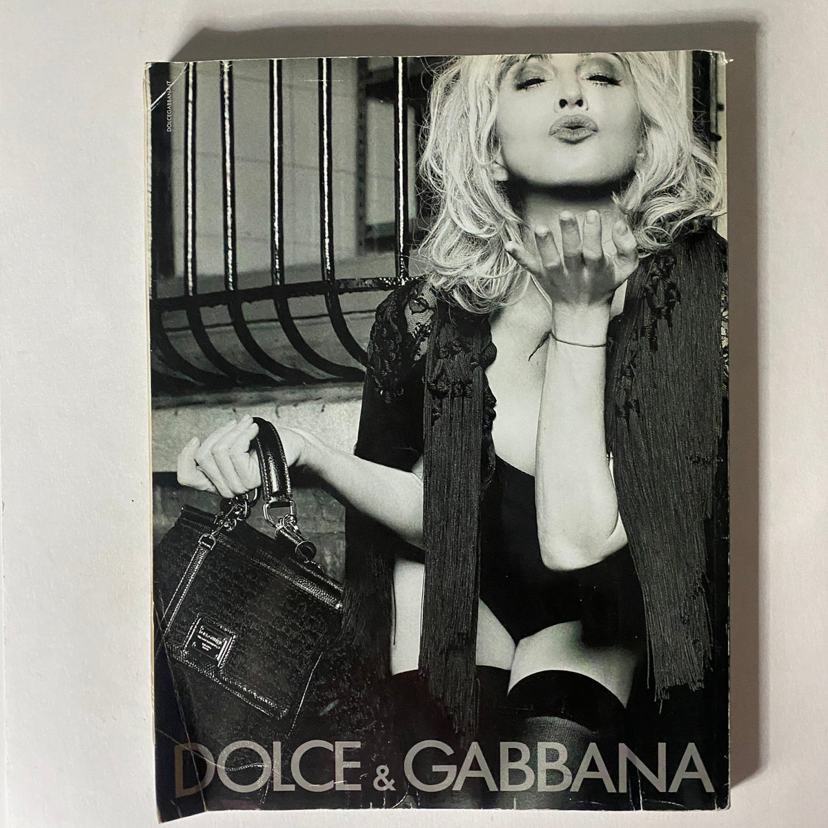 Cover of a vintage magazine featuring Dolce & Gabbana, displaying a glamorous model with sultry makeup in a black and white aesthetic.