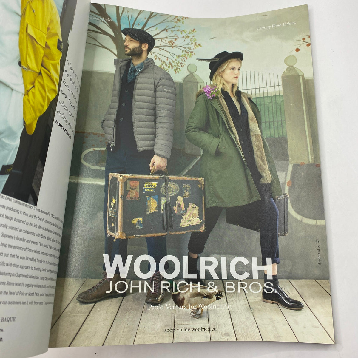 Fashion advertisement from i-D Magazine Fall 2014 No. 333 showcasing Woolrich John Rich & Bros, featuring male and female models with luggage.