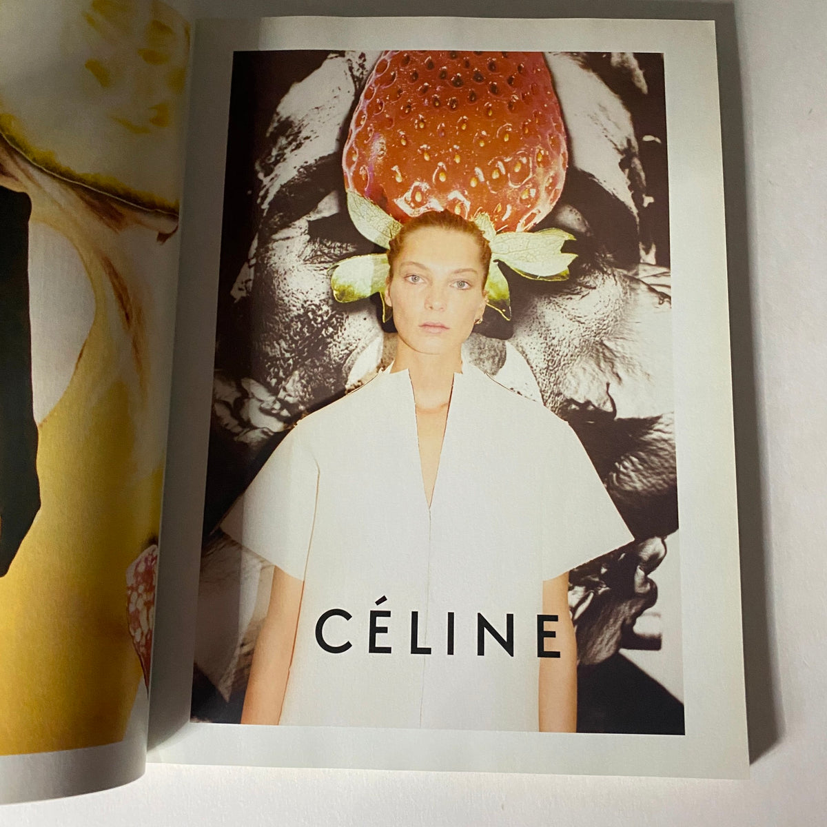 Artistic advertisement page from i-D Magazine Spring - Summer 2011 for CÉLINE, featuring a model against a striking background with a strawberry design.