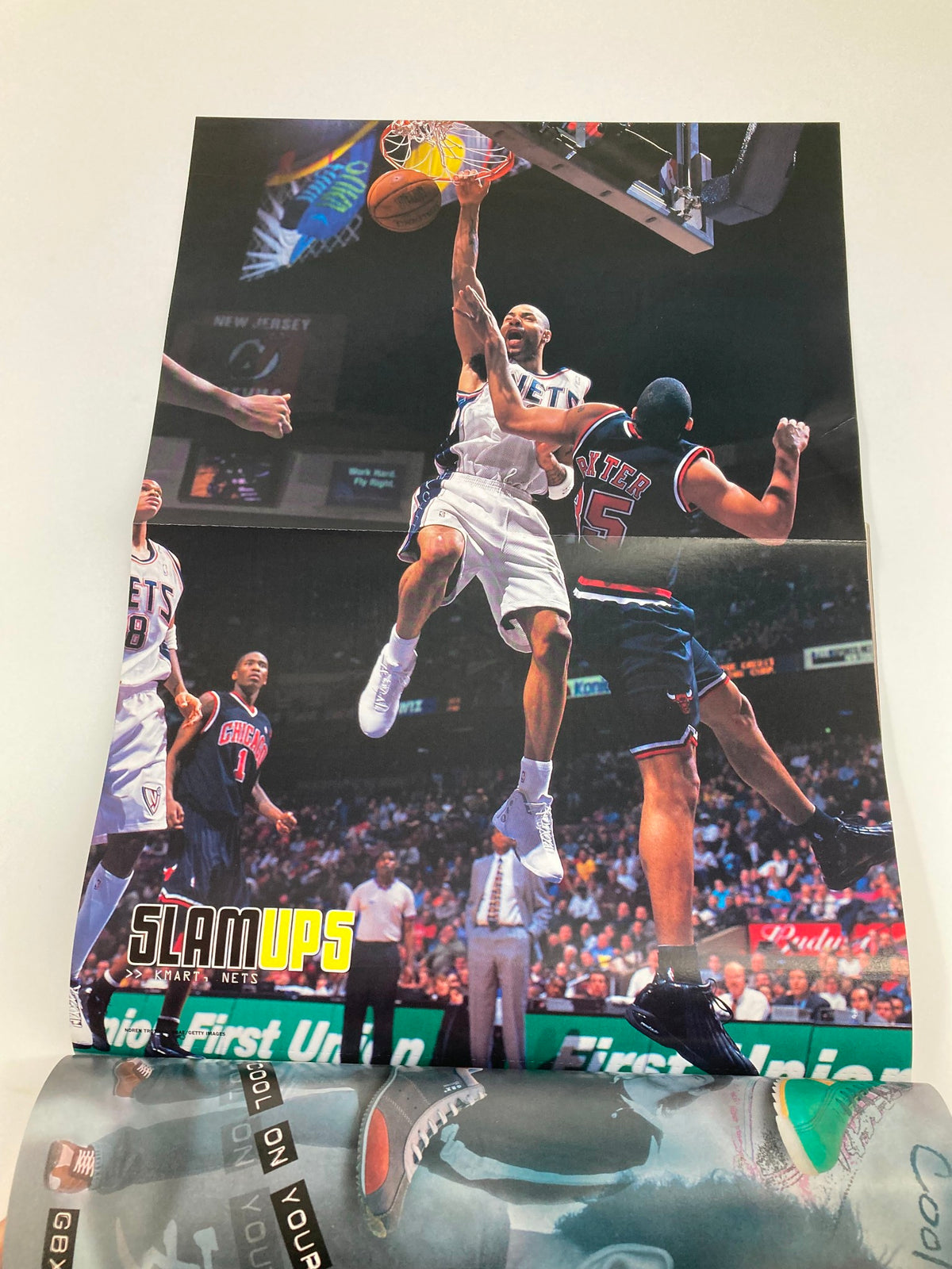 Slam Magazine April 2003 NBA issue featuring a dynamic basketball moment with players in action. Includes a collectible poster of Allen Iverson, making it a valuable addition for fans and collectors.