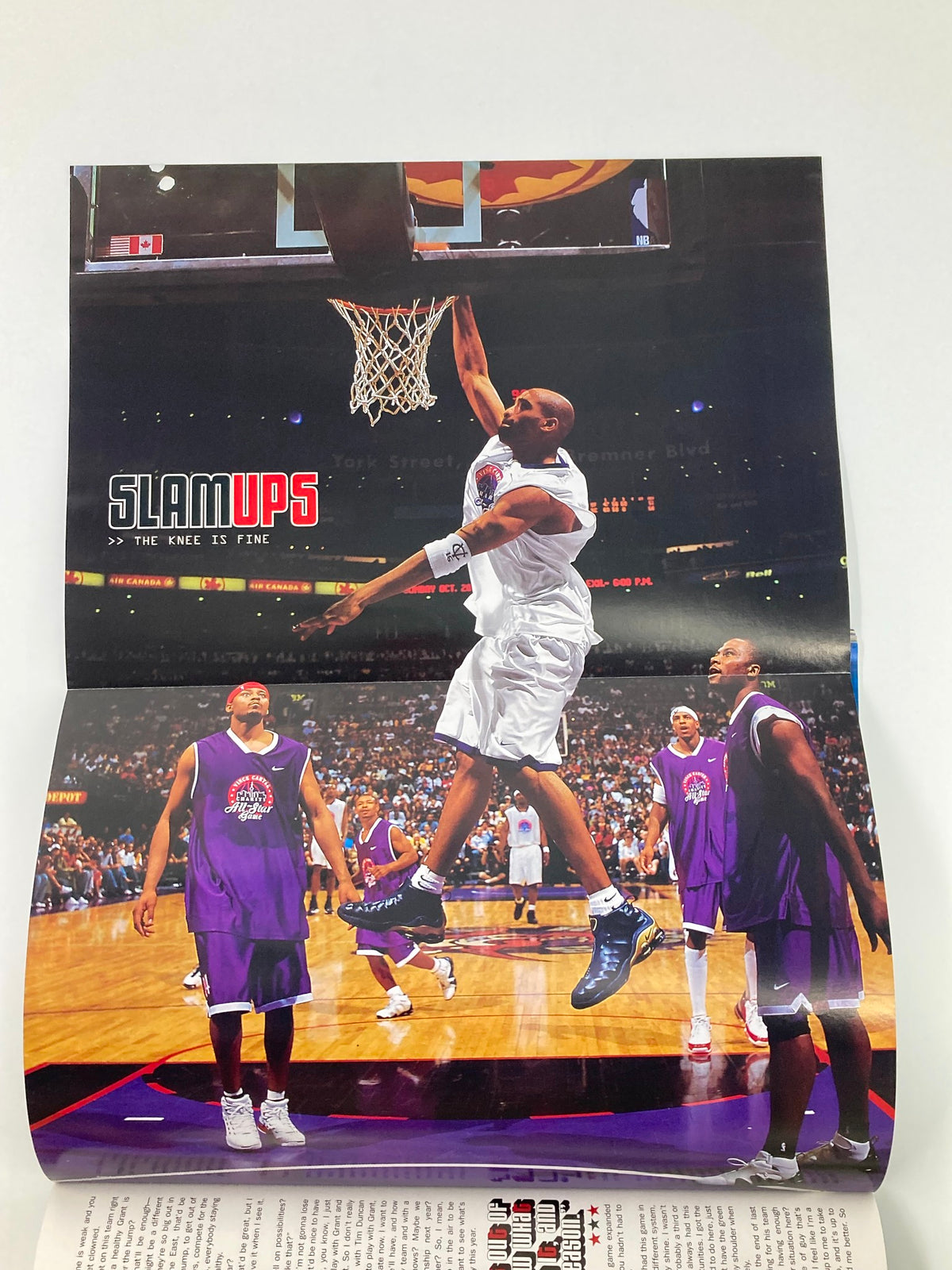 Another poster from Slam Magazine November 2002 illustrating an intense moment with a player executing a dunk amidst defenders during a basketball game, labeled under 'SLAMUPS'.