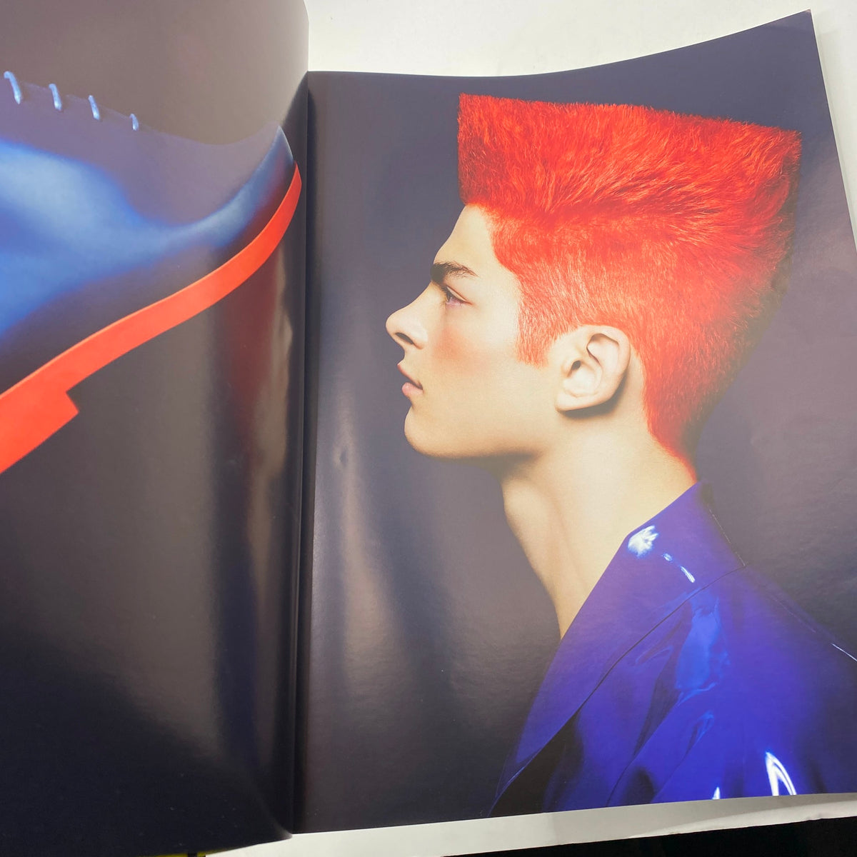 Hero Men Fashion Magazine 2015 featuring a striking model with bright red hair and a profile view against a dark background, showcasing contemporary fashion trends.