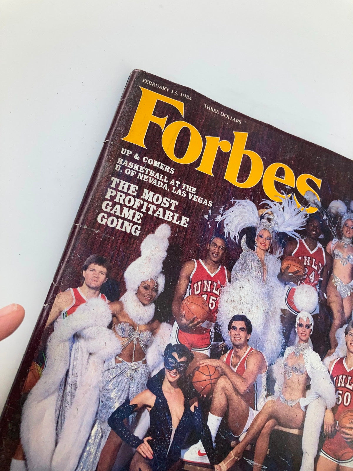 Close-up view of the February 13, 1984 Forbes Magazine cover showcasing 'Basketball: The Most Profitable Game Going' with performers and athletes in attire.