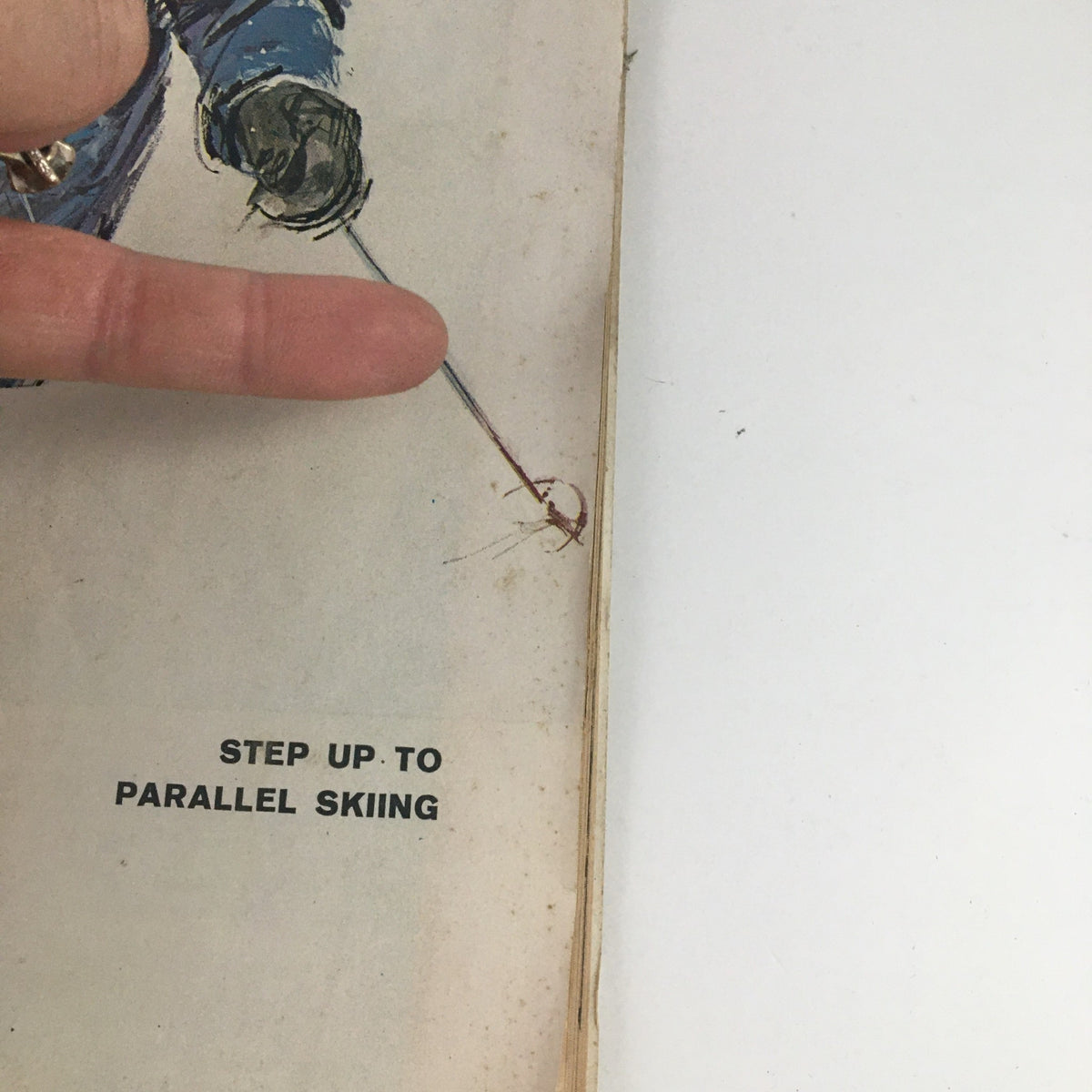 Close-up of the Sports Illustrated Magazine November 23 1964, showing the text 'Step Up To Parallel Skiing' with a finger pointing at it.
