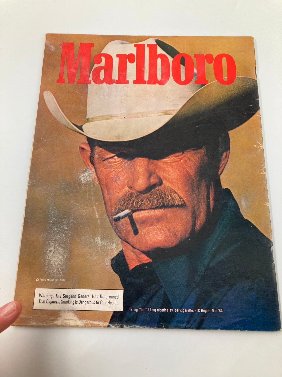 Cover of a vintage 1984 Marlboro magazine featuring a cowboy with a cigarette, emphasizing a warning about the health risks of smoking.