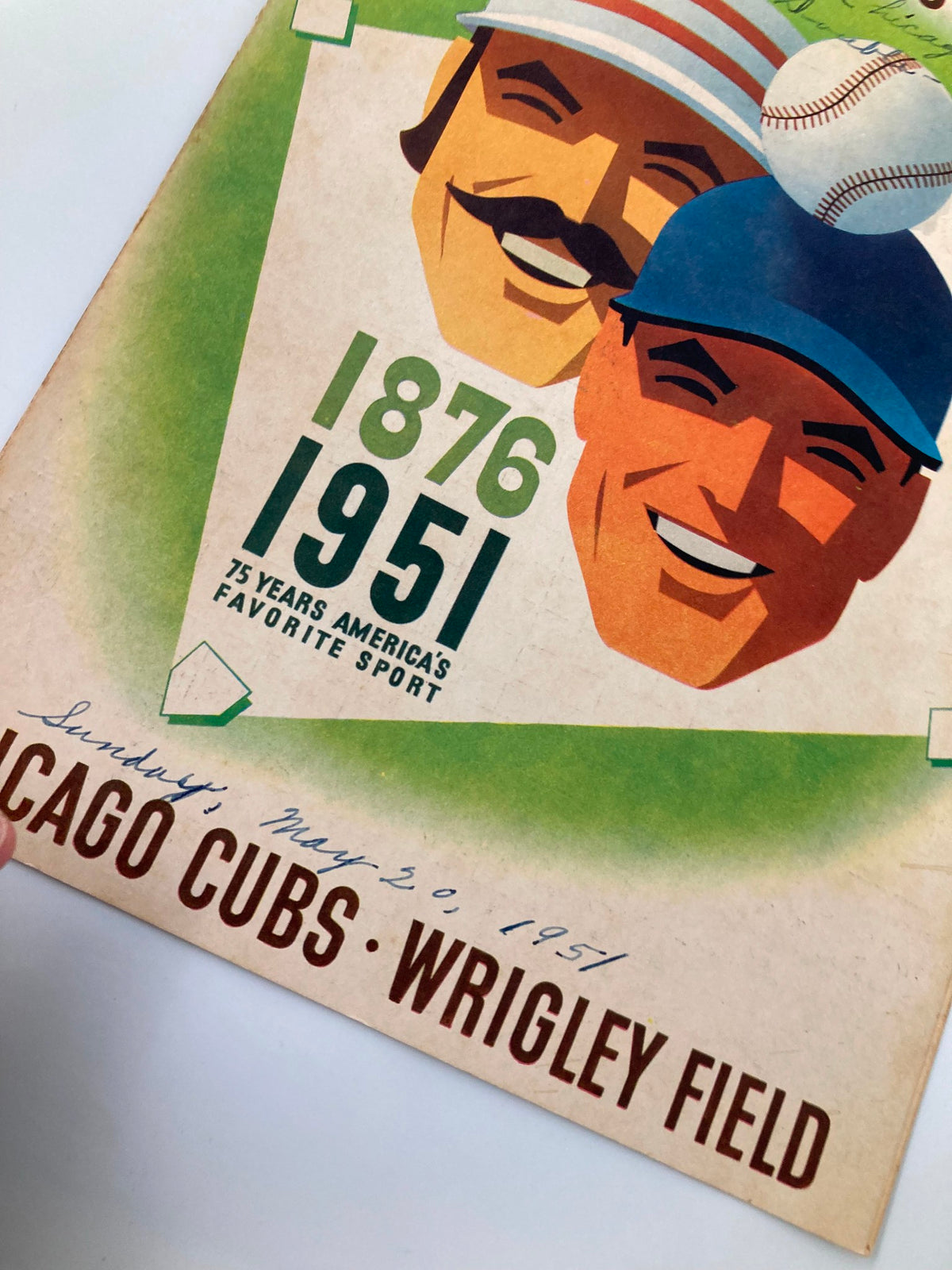 Detailed shot of the 1951 MLB Chicago Cubs vs Boston Red Sox Official Program revealing the date and venue, highlighting the vibrant artwork of the baseball players.