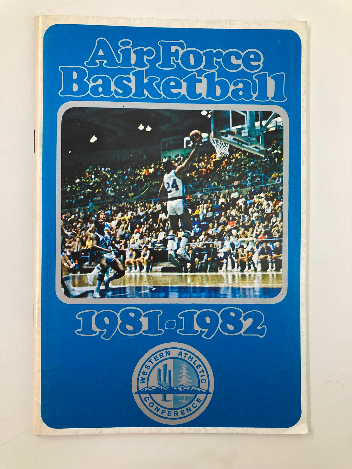 Cover of the 1981-1982 Western Athletic Conference Air Force Basketball Program featuring a player in action on the basketball court, showcasing a vibrant blue design.