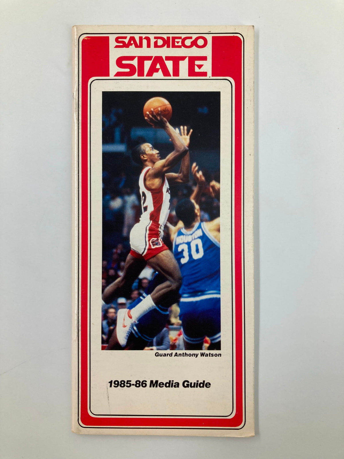 1985-1986 San Diego State University Basketball Media Guide featuring Guard Anthony Watson, showcasing a dynamic basketball action shot on the cover.
