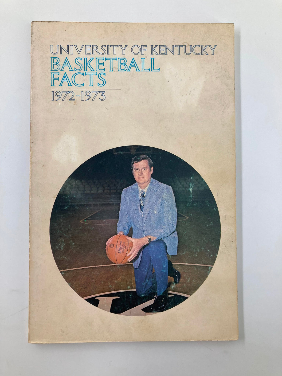 Cover of the 1972-1973 NCAA University of Kentucky Basketball Facts program featuring a man in a suit holding a basketball on a court.