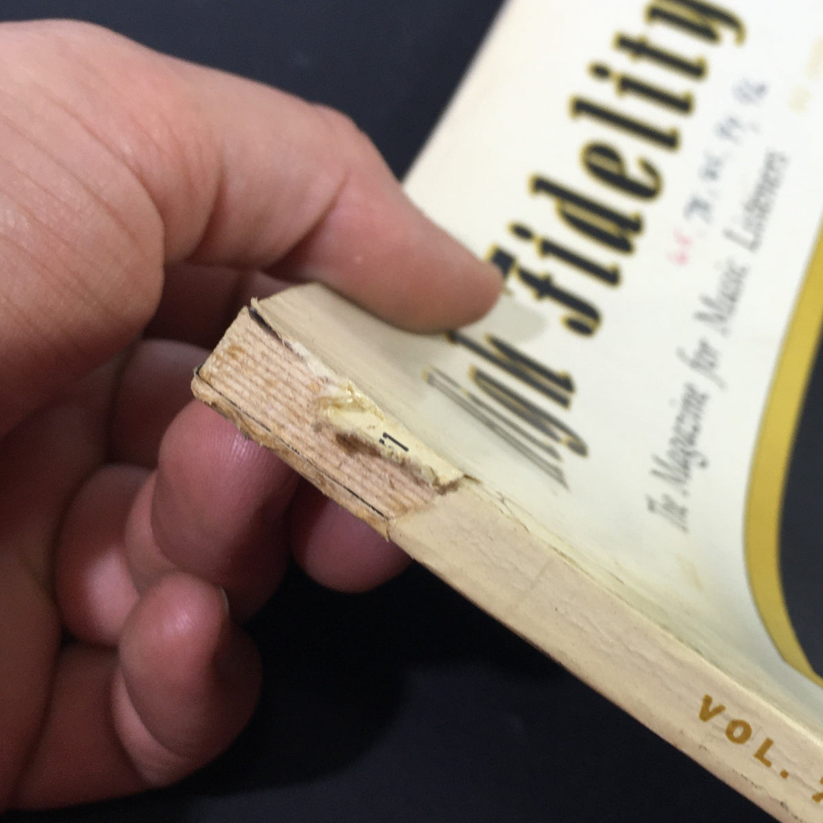 Close-up view of the spine and edge of the March 1957 High Fidelity Music Magazine, showing signs of wear and historical detailing. This collectible magazine features a cover story on Arturo Toscanini, making it a valuable piece for music enthusiasts and collectors.