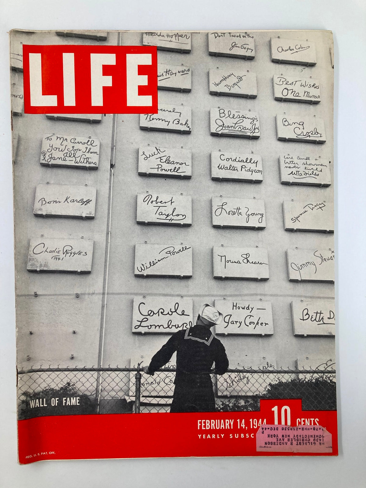 Cover of Life Magazine from February 14, 1944, featuring the Wall of Fame, showcasing signatures of notable figures from the time with a sailor observing the display.