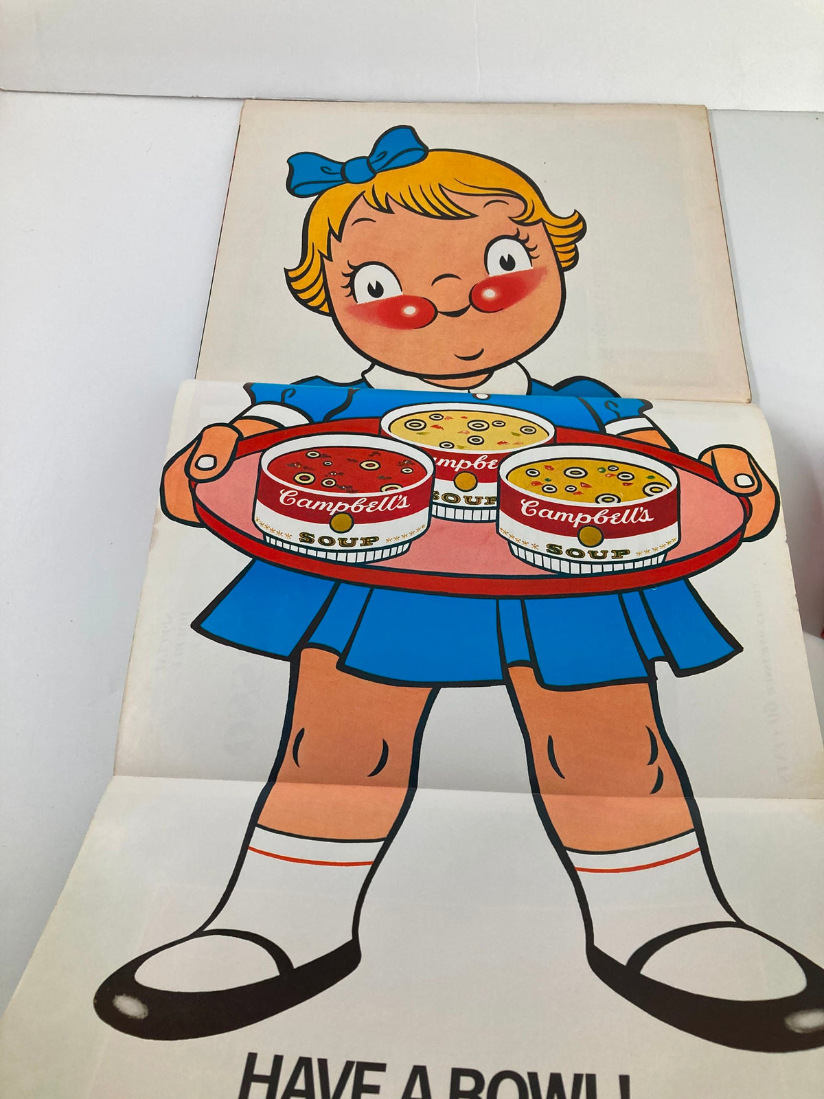 Illustration from the VTG Life Magazine December 27 1968 showing a cheerful girl holding a tray of Campbell's Soup cans, part of a vintage advertisement.